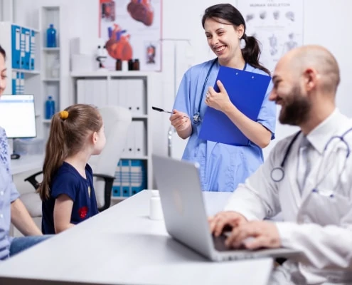 medical staff smiling at child FPJF8HA